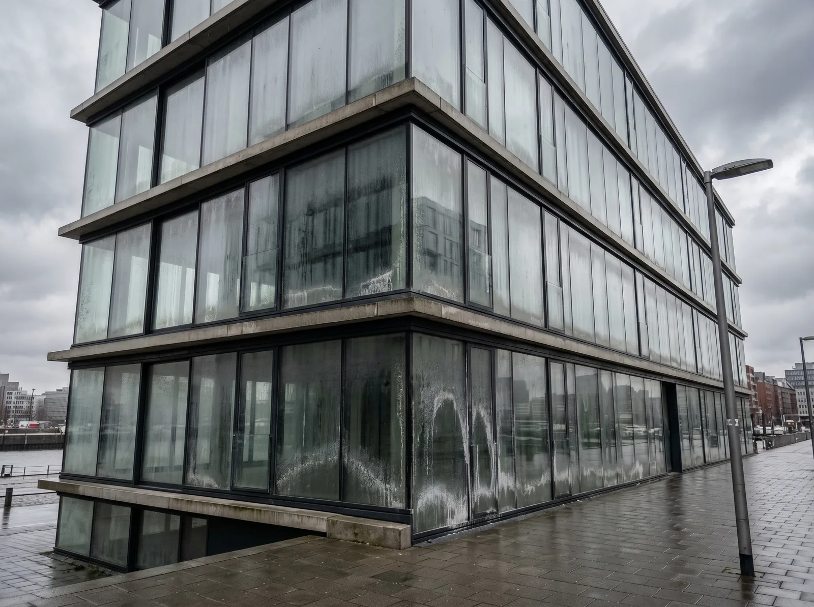 Bürofassade in HafenCity mit verschmutzten Glaspaneelen